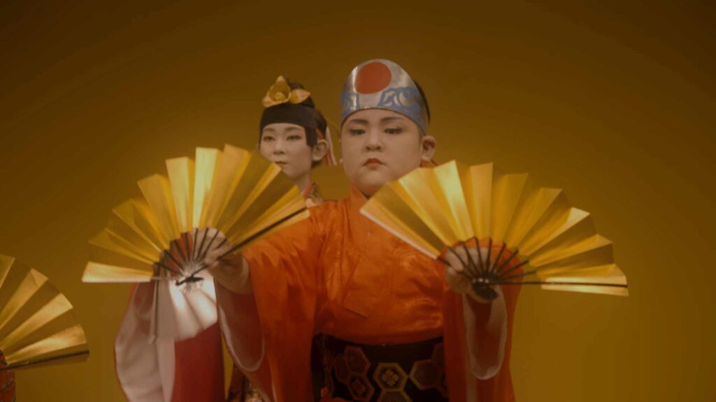 Två unga dansare i traditionella scendräkter från Okinawa